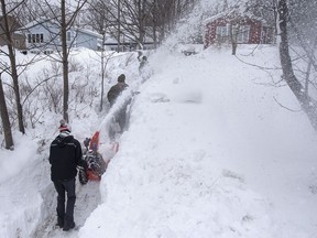 Soldiers from the 4th Artillery Regiment based at CFB Gagetown get help from a snowblower-equipped neighbour as they clear snow at a residence in St. John's on Monday, January 20, 2020. It's now Day 5 of the state of emergency in the St. John's, N.L., as cleanup continues from Friday's massive blizzard that dumped 76 centimetres of snow in the area.