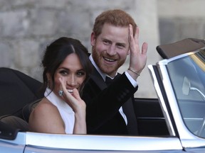 In this Saturday, May 19, 2018 photo the newly married Duke and Duchess of Sussex, Meghan Markle and Prince Harry, leave Windsor Castle in a convertible car after their wedding in Windsor.