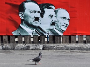This photo taken on July 28, 2014 shows a placard depicting Adolf Hitler, Joseph Stalin and Russian President Vladimir Putin displayed on the Maidan camp on Independence Square in Kiev.