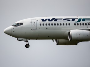 A WestJet Airlines Boeing 737-700 plane prepares to land. On Feb. 4, 2020, Peel regional police have charged a man with mischief after false coronavirus claims.