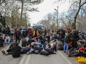 Refugees coming from Turkey rests  as they try to cross the Greek Turkish border on February 28, 2020 in Edirne, Turkey.