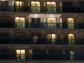 A passenger is seen in her cabin of the quarantined Diamond Princess cruise ship docked at the Daikoku Pier at night on February 20, 2020 in Yokohama, Japan.