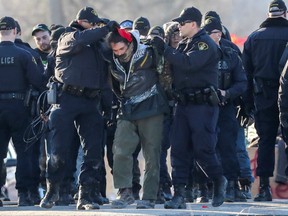 Police officers make an arrest during a raid on a Tyendinaga Mohawk Territory camp next to a railway crossing in Tyendinaga.