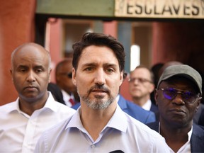 Canadian Prime Minister Justin Trudeau (C), walks with Abdoulaye Diop (R), the Minister of Culture and Communication of Senegal, and Ahmed Hussen (L) Canadian Member of Parliament upon his arrival on Goree Island off the coast of Dakar on February 12, 2020.