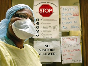 A nurse wears the protective clothing used when treating patients with atypical pneumonia (SARS) outside the door of a quarantined patient diagnosed with the illness in a ward at Sunnybrook and Women's Hospital in Toronto on March 17, 2003.