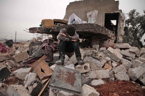 A Syrian boy cries as he sits on the rubble of the house where he lived with his displaced family in the village of Kafr Taal, Syria, after a reported pro-regime bombardment on Jan. 20, 2020.