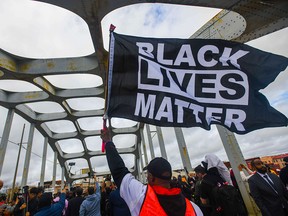 A Black Lives Matter demonstrator waves a flag on the Edmund Pettus Bridge in Selma, Ala., on March 3, 2019, during a commemoration of the March 7, 1965 "Bloody Sunday" when armed police attacked civil rights marchers there.