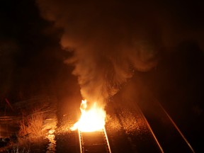 A fire from a lit tire burns on train tracks just after the first Canadian National Railway freight train passed through the Tyendinaga Mohawk Territory in weeks, following a police raid earlier in the day in Tyendinaga, Ont., on Feb. 24.