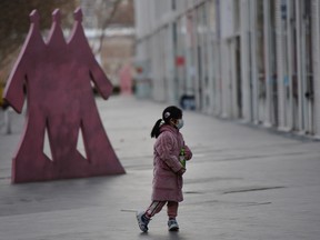 A child wears a face mask near a commercial and residential complex, as the country is hit by an outbreak of the novel coronavirus, in Beijing's central business district, China February 18, 2020.