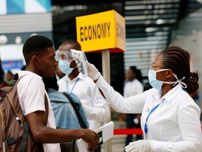 A health worker checks the temperature of a traveller as part of the coronavirus screening procedure at the Kotoka International Airport in Accra, Ghana January 30, 2020.