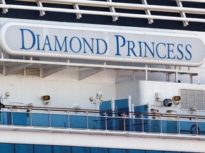 A passenger wearing a mask stands on the deck of the cruise ship Diamond Princess, as the vessel's passengers continue to be tested for coronavirus, at Daikoku Pier Cruise Terminal in Yokohama, south of Tokyo, Japan February 13, 2020.