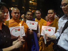 Buddhist monks and Chinese consulate officials take part in a candle march vigil to show solidarity with China in the fight against the  COVID-19 coronavirus outbreak, near Gateway of India in Mumbai on February 20, 2020.