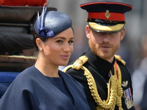 In this file photo taken on June 08, 2019 Britain’s Meghan, Duchess of Sussex (L) and Britain’s Prince Harry, Duke of Sussex (R) return to Buckingham Palace after the Queen’s Birthday Parade, ‘Trooping the Colour’, in London.