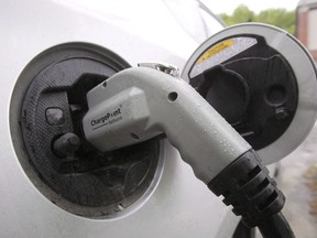 An electric vehicle is shown attached to a charging station on Tuesday, June 18, 2013 in Montpelier, Vt.