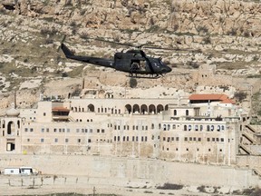 A Canadian Forces Griffon helicopter passes the Monastery of Mar Mattai/St Matthew, February 20, 2017 in northern Iraq.