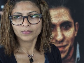 Ensaf Haidar, wife of Raif Badawi, stands next to a poster of a book of articles written by the imprisoned Saudi blogger, in Montreal, Tuesday, June 16, 2015. Haidar, a Canadian citizen who lives in Sherbrooke, Que., says through her Twitter account that the last time she heard from Badawi was on Jan. 14.