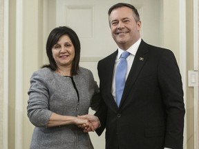 Alberta Premier Jason Kenney shakes hands with Adriana LaGrange, Minister of Education after being is sworn into office, in Edmonton on Tuesday April 30, 2019. The Alberta government says it is changing the way it will fund kindergarten and grade schools starting this fall. The plan includes streamlining grants, capping administration costs and reworking the per-student funding formula.