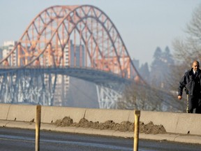 An RCMP officer walks along the causeway to the Pattullo Bridge which was closed after wooden supports at the south end of the bridge caught fire in Surrey, B.C., on Sunday, January 18, 2009. The B.C. government has awarded a contract for the replacement of the Pattullo Bridge in Metro Vancouver.