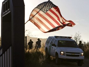 An American flag on a nearby resident's home waves in the breeze near a U.S. Border Patrol truck blocking the road northwest of Nogales, Ariz. on Dec. 15, 2010. With a new continental trade deal all but done, it might be tempting for the average Canadian to think that cross-border business anxiety will soon be a thing of the past, at least for a while.
