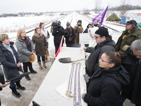 Kanenhariyo, centre right, speaks to an OPP Liasion team as members of the Mohawk Territory block the CN/VIA train tracks for a sixth day in Tyendinaga Mohawk Territory, near Belleville, Ont., on Tuesday, Feb. 11, 2020. The RCMP has formally ended its enforcement operations in a region of northern B.C. that's at the centre of a pipeline dispute as protests across the country continue to cause disruptions, most notably to Canada's rail network.