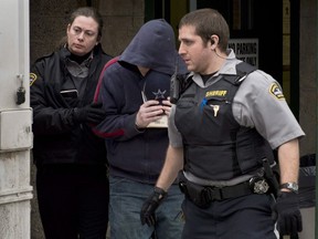 Sub-Lt. Jeffrey Paul Delisle is escorted by sheriffs from Nova Scotia provincial court in Halifax on Friday, Feb. 8, 2013. Federal officials lost or possibly destroyed sensitive records about the case of a naval officer convicted of selling secrets to Russia, an investigation by Canada's information commissioner has found.