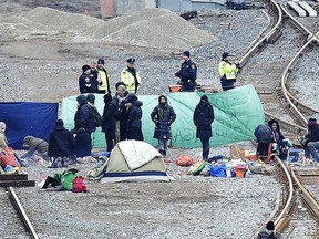 Police speak with protesters camped on GO Transit railroad tracks in Hamilton, Ont., on Tuesday, Feb. 25, 2020, as they protest in solidarity with Wet'suwet'en Nation hereditary chiefs attempting to halt construction of a natural gas pipeline on their traditional territories.