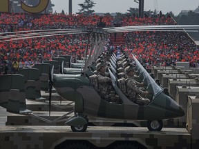 Chinese soldiers sit in small helicopters as they ride on trucks in a parade to celebrate the 70th anniversary of the founding of the People's Republic of China, at Tiananmen Square on Oct. 1, 2019, in Beijing.