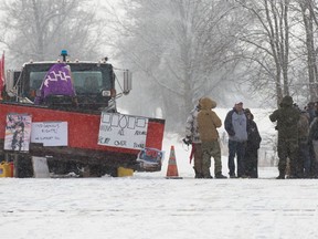 People stand near the train train tracks on day 8 of the train blockade in Tyendinaga, near Belleville, Ont., on Thursday Feb. 13, 2020, in support of Wet'suwet'en's blockade of a natural gas pipeline in northern B.C.