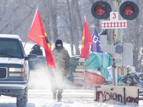 A land protector walk on the closed train tracks on the ninth day of the blockade in Tyendinaga, near Belleville, Ont., on Friday Feb. 14, 2020, as they protest in solidarity with the Wet'suwet'en hereditary chiefs opposed to the LNG pipeline in northern British Columbia.