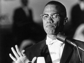 American political activist and radical civil rights leader Malcolm X (1925 - 1965) standing at a podium during a rally of African-American Muslims held in a Washington, D.C. arena.