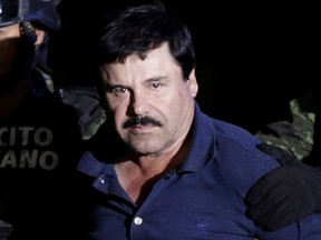 Recaptured drug lord Joaquin "El Chapo" Guzman is escorted by soldiers at the hangar belonging to the office of the Attorney General in Mexico City, Mexico January 8, 2016.