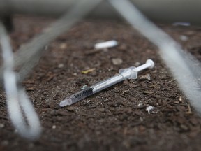 A discarded needle sits behind a fence at a safe injection site on Victoria Street in downtown Toronto, in a file photo from July 4, 2018.