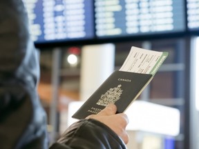 A man with a Canadian passport and boarding pass looks at the airport departure. Thirteen Canadians have been detained in Ethiopia on allegations of dispensing expired medicine.