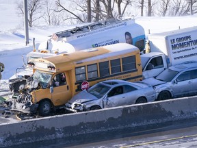 A fireman walks past a massive pileup involving numerous vehicles on the south shore of Montreal in La Prairie, Que. on Wednesday, February 19, 2020.