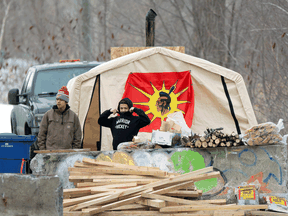 Protestors stand by a blockade closing a road in Kahnawake Mohawk Territory, south of Montreal, Feb. 25, 2020.
