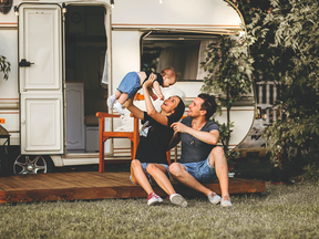 A family smiles in front of their RV