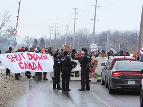 Police monitor demonstrators blocking a rail line in Kingston, Ont., on Feb. 9, 2020.