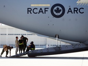 Technicians on the ramp of a CC-177 Globemaster III plane await the arrival of their cargo   Tuesday, July 3, 2018 at Canadian Forces Base Trenton, Ont. Nearly 300 Canadians evacuated from Wuhan will be quarantined for 14 days at the base camp.