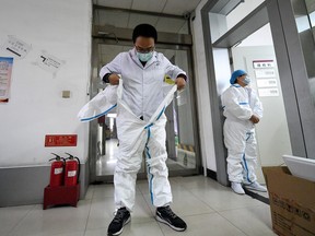 A worker puts on his protective suit before entering a laboratory at a centre for disease control and prevention, as the country is hit by an outbreak of the novel coronavirus, in Taiyuan, Shanxi province, China February 14, 2020.