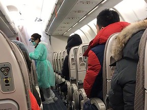 People sit on a plane destined for Canada at the Wuhan Tianhe International Airport early in the morning on Feb. 7, 2020.