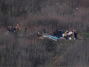 Los Angeles County Fire Department firefighters and coroner staff recover the bodies from the scene of a helicopter crash in Calabasas on January 26, 2020.