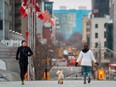 A jogger keeps his distance from a woman walking her dog