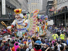 A float in the Rex parade turns on to Canal Street to large crowds with out outstretched arms on Mardi Gras Day.