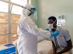 A medical staff member wearing protective equipment places a face mask on a mock patient at the Wilkins Infectious Diseases Hospital in Harare, Zimnbabwe on March 11, 2020.