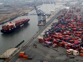 A container ship is seen as hundreds of shipping containers are seen stacked at a pier at the Port of New York and New Jersey in Elizabeth, New Jersey, U.S., March 30, 2020.