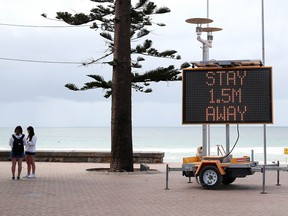 A sign reminding residents and tourists of new social distancing rules is displayed at Manly Beach on March 23, 2020 in Sydney, Australia.