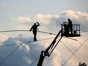 Nik Wallenda raises his fist as  he completes his world record high wire walk across the Calgary Stampede midway on Monday evening, July 8, 2019.