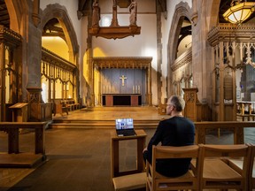 A church parishioner watches a laptop inside Liverpool Parish Church (Our Lady and St Nicholas) in Liverpool, England, during the Church of England's first virtual Sunday service given by the Archbishop of Canterbury Justin Welby