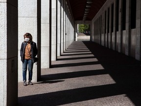 A woman waits to enter a bank in the EUR neighbourhood in Rome