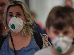 Passengers wearing masks as a precautionary measure to avoid contracting COVID-19 arrive on a flight from Italy at Guarulhos International Airport, in Guarulhos, Sao Paulo, Brazil on March 2, 2020.